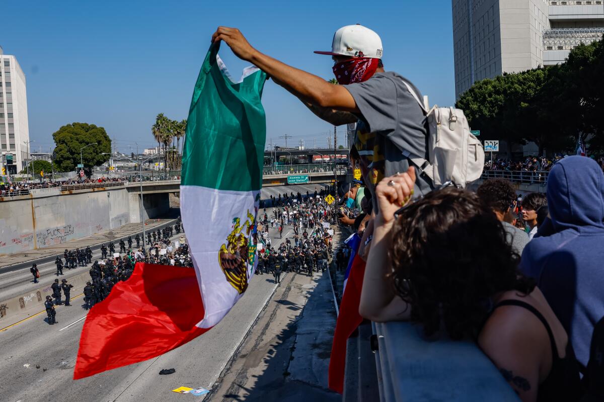 Protesters walk on the 101 Freeway as they clash with law enforcement in downtown Los Angeles