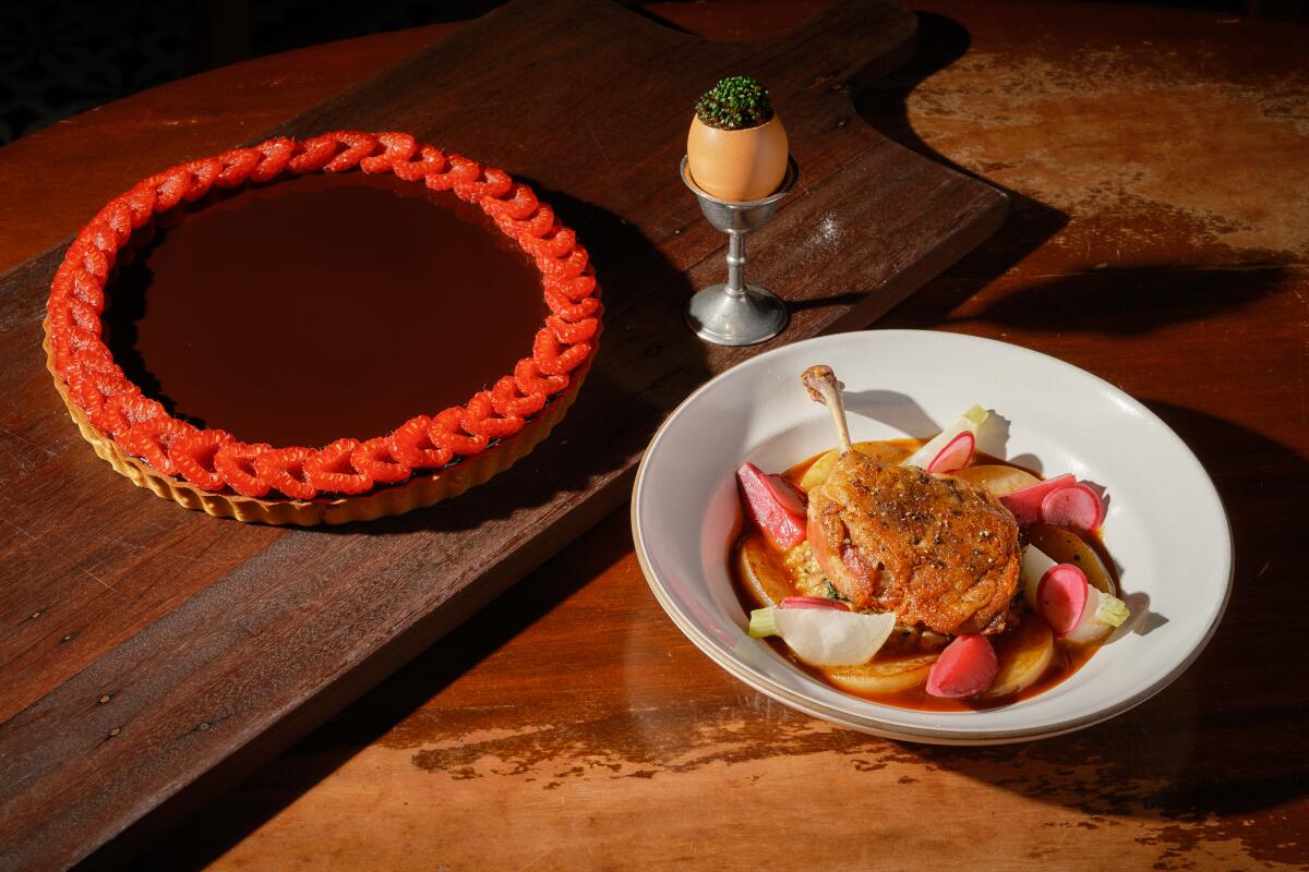 A French chocolate and rapsberry tart, left, a soft egg in shell with caviar and duck leg confit.