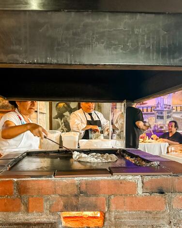 Tortillas being made on a large flat grill