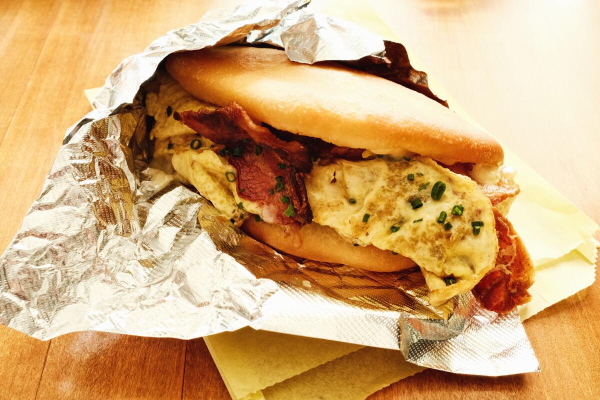 A bacon, egg and cheese breakfast on aluminum foil at Cafe Tropical