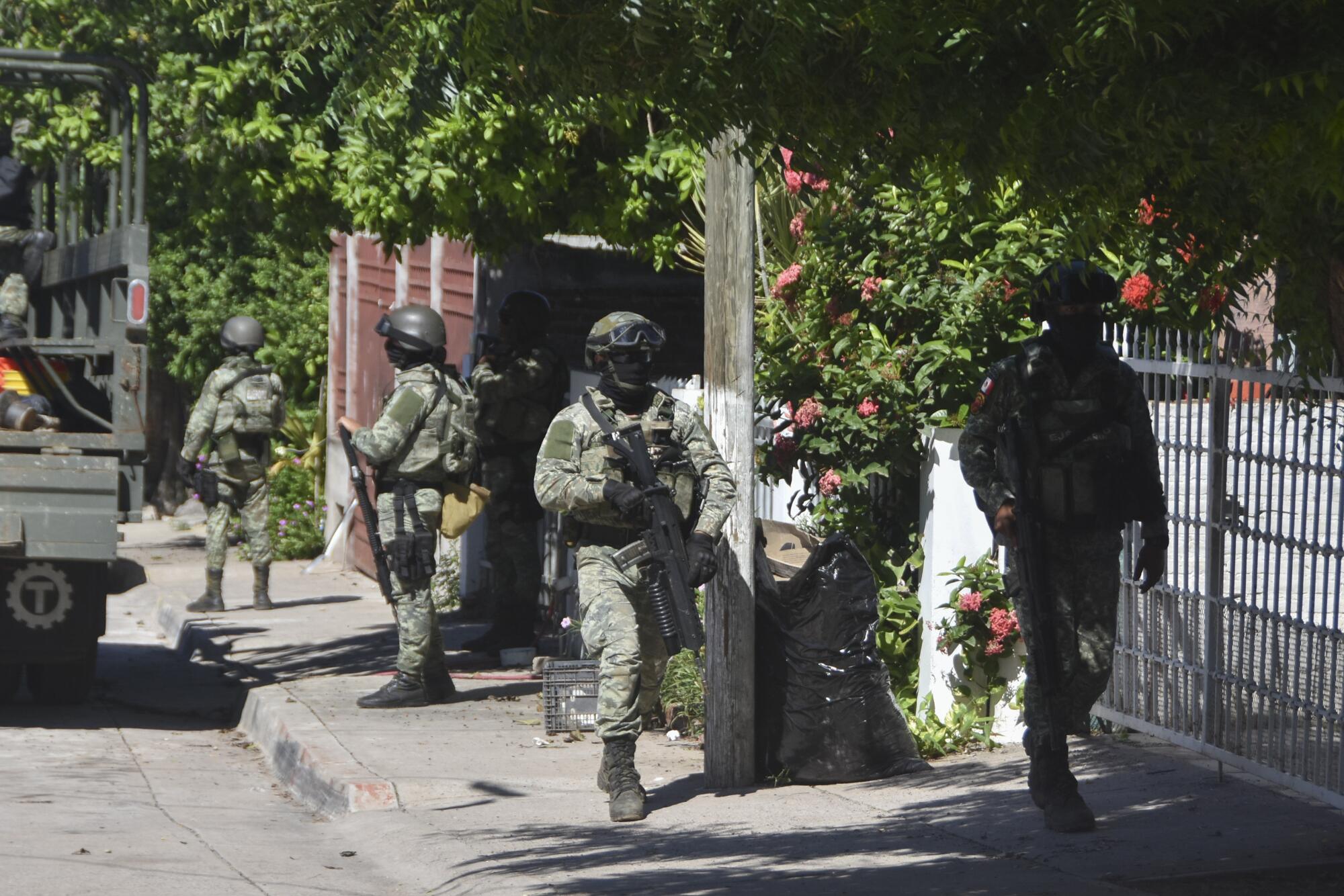 Armed soldiers in fatigues on a street
