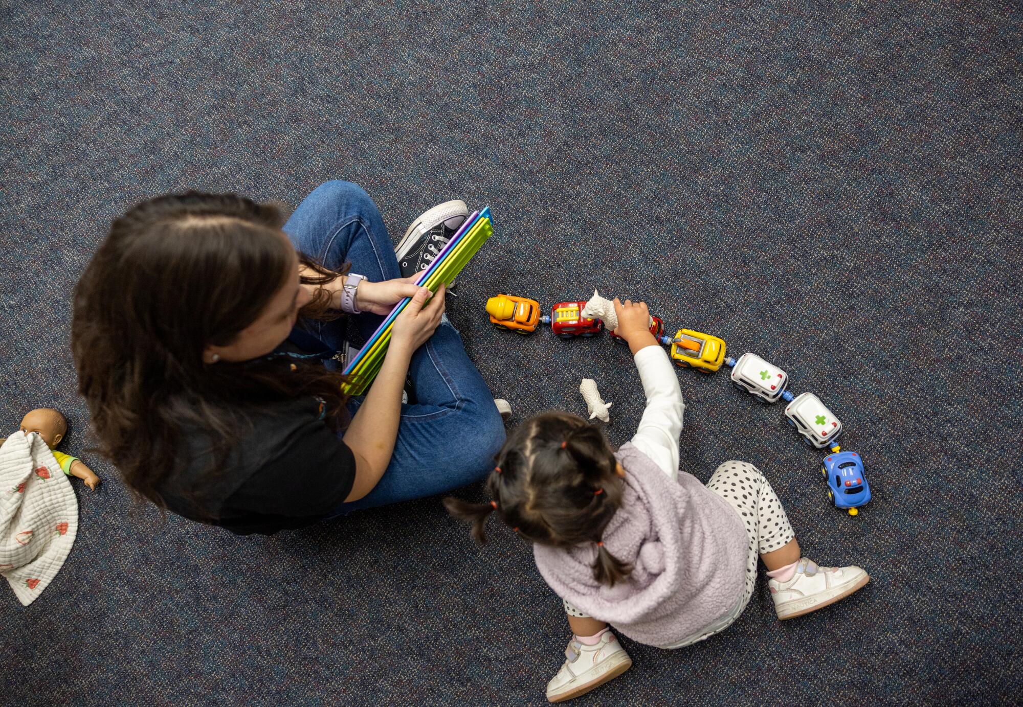 Viviana Banuelos, teacher, left, plays with a child at the Pacific Clinics Head Start in Pasadena.