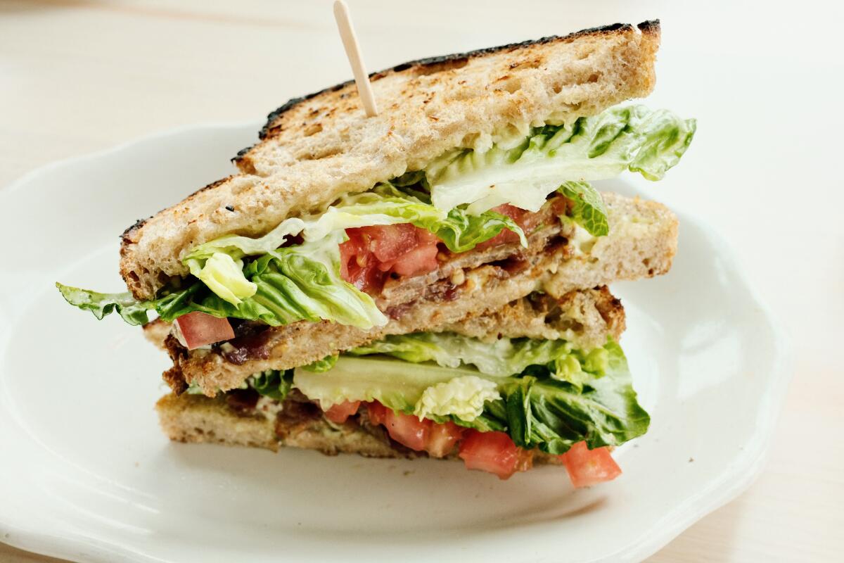 Two halves of a stacked BLT at Colossus Bread's San Pedro cafe