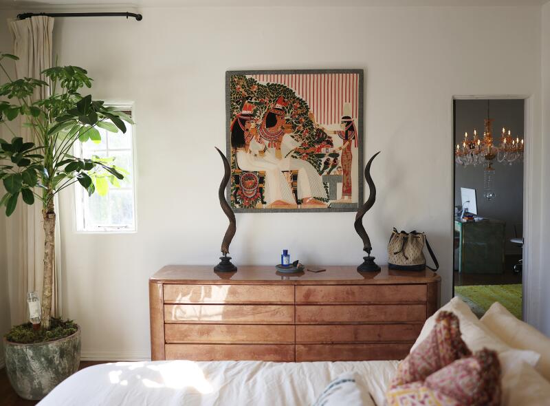 A bed and dresser in neutral tones in a bedroom