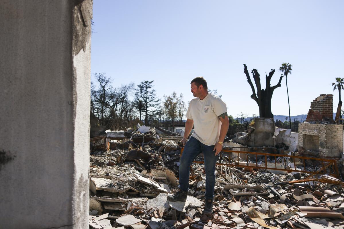 A man surveys the rubble of his home in Altadena