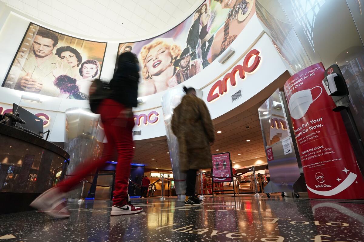 Movie patrons gather in the lobby of an AMC theater.