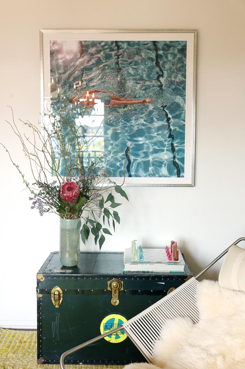 A vignette of a trunk, flowers in a vase and painting in a Hollywood penthouse in Whitley Heights.