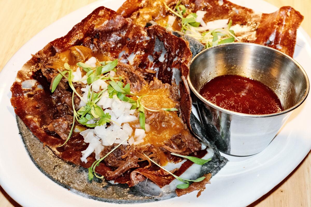 Two beef cheek quesabirria tacos on fresh blue corn tortillas at Jaime Taqueria in El Segundo.