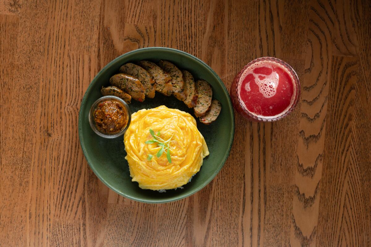 BERKELEY, CA - MAY 14: Lava eggs with sai oua and a glass of blood orange juice at Tanzie's Cafe in Berkeley, CA on Wednesday, May 14, 2025. (Myung J. Chun / Los Angeles Times).