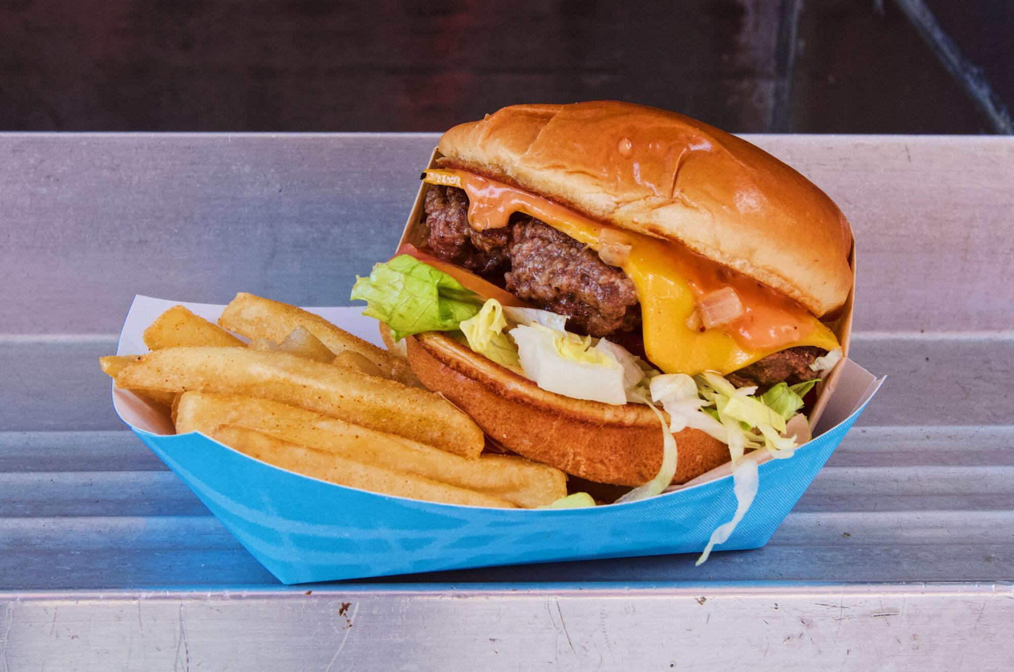 A photo of a single Thicc Burger cheeseburger with fries at the food truck in Los Angeles.