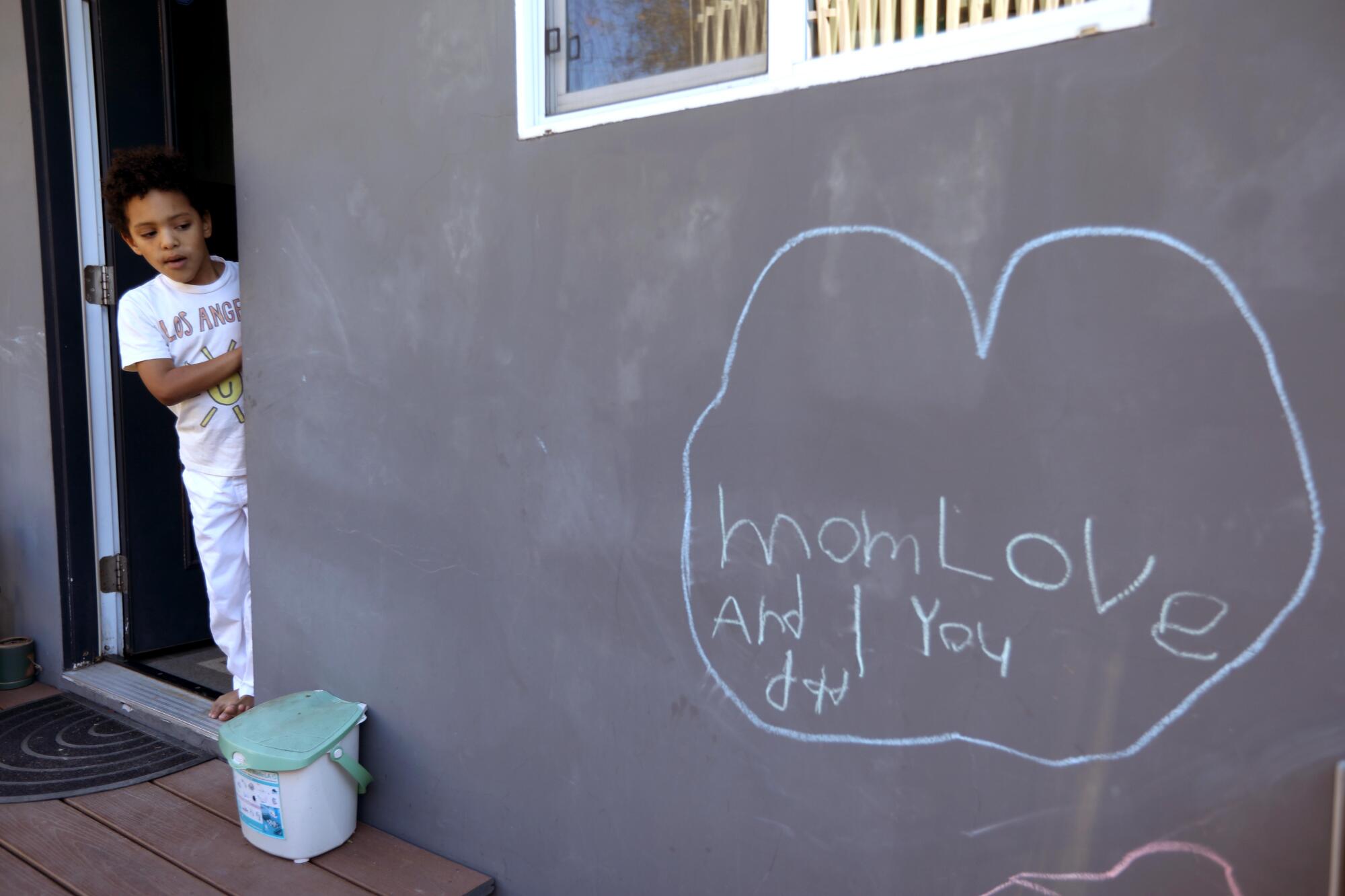 Lorenzo Dabel, 7, looks over a chalk drawing he made for his parents.
