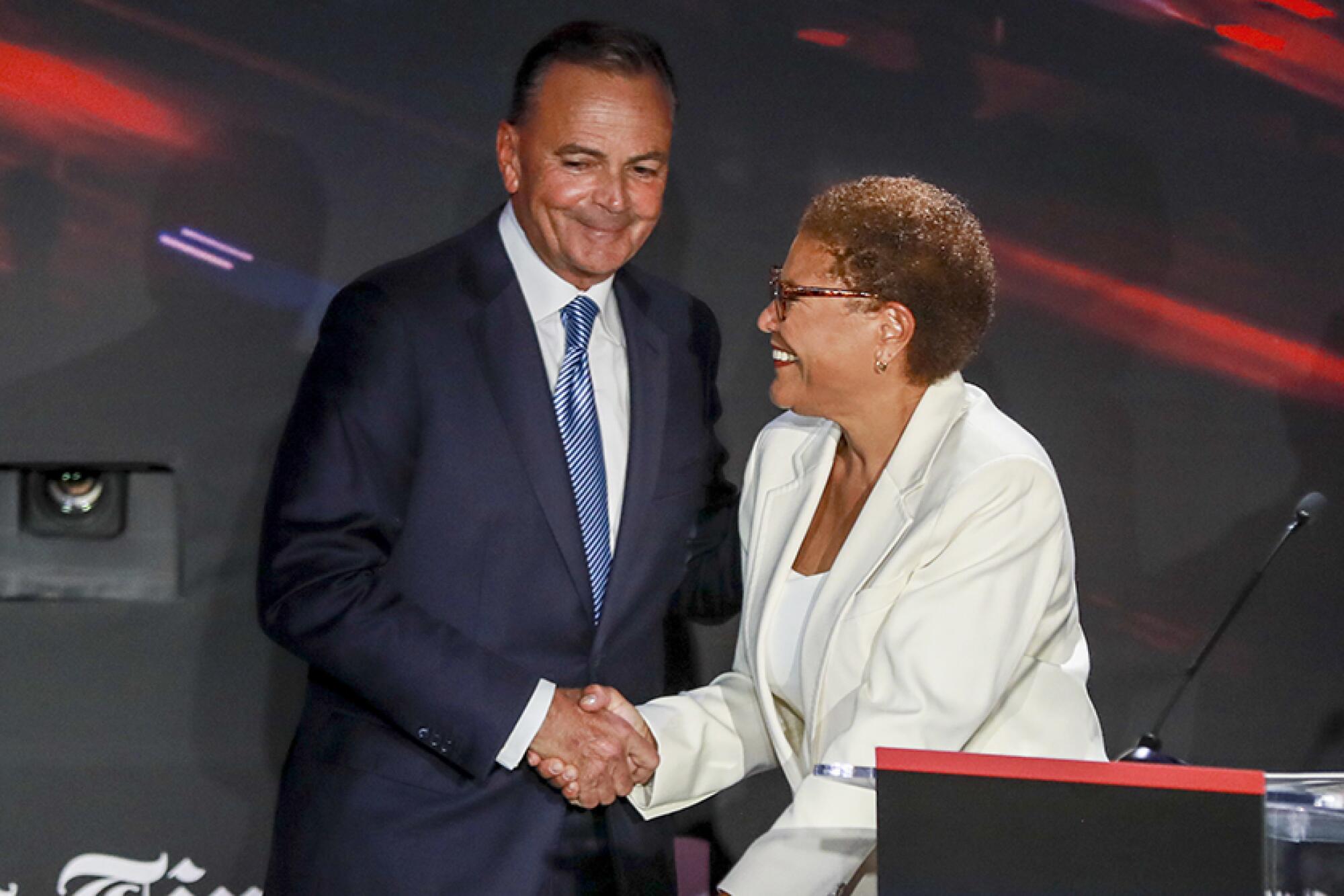 A man and woman in suits shake hands