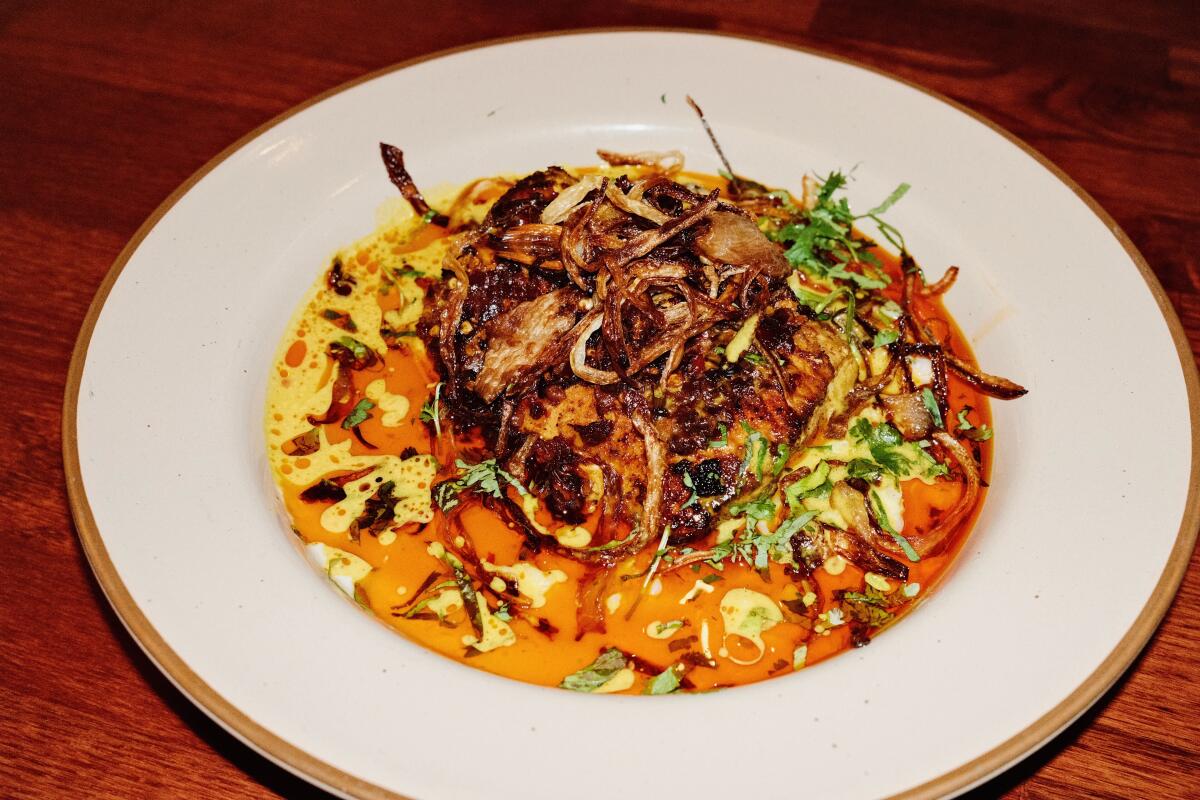 Coconut milk risotto with baked mahi mahi, fried onions and tomato gravy at Kurrypinch in East Hollywood