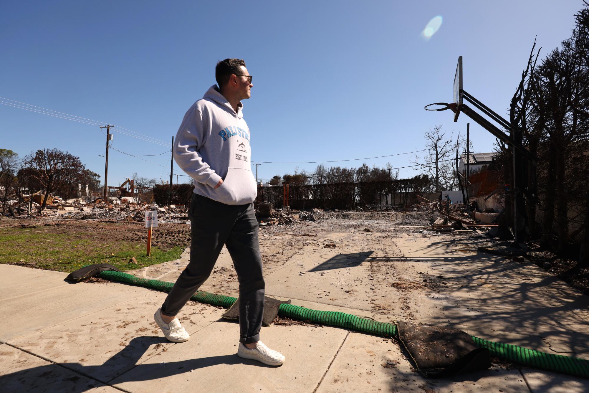 JJ Redick looks at a basketball hoop left standing where a home was destroyed in the Palisades fire.